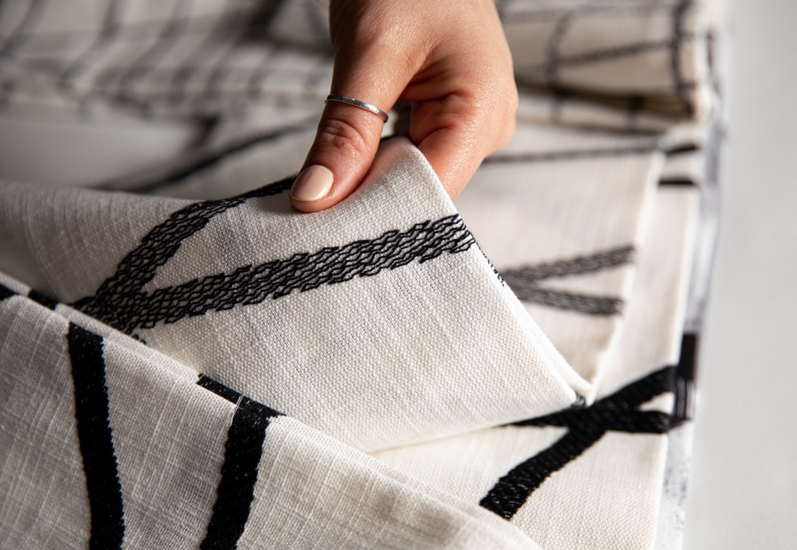 Hand picking up or choose white fabric with black patterned