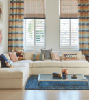 Colourful pattern mixing blinds with curtains in traditional living room style