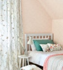 beige and white butterfly pattern curtains in cute kids room on pale pink walls