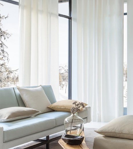 White sheer curtains in contemporary lounge room on large windows