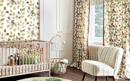 Nursery with cot and chair and wardrobe with curtains hanging with Villa Nova Picture Book fabric