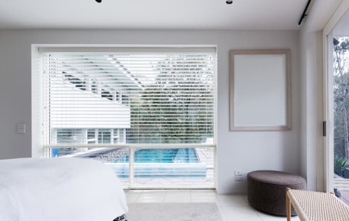 white venetian blinds in contemporary bedroom on white walls