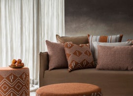 white sheer curtains in african modern lounge room on brown textured walls