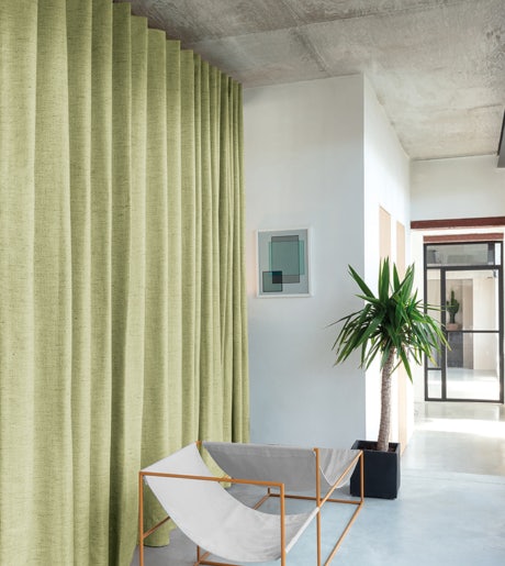 green textured curtains in modern boho lounge room on white walls
