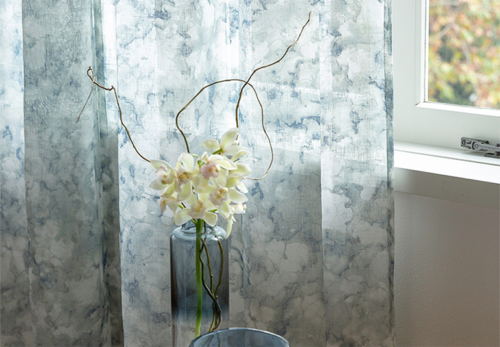 blue and white blotchy pattern sheer curtains on white walls