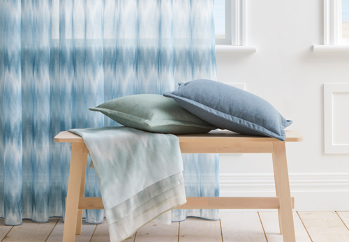 blue and white tie dye pattern sheer curtains in beachy lounge room on white walls