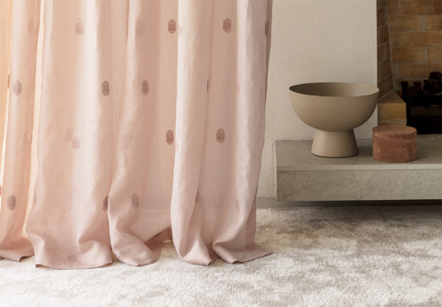 pink spotted sheer curtains close up on grey walls