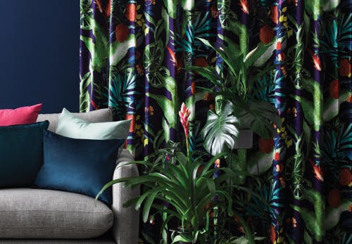 purple green red tropical foliage leaf pattern curtains in contemporary lounge room on navy blue walls