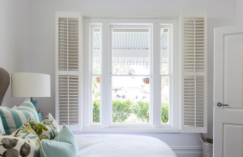 white shutters in contemporary bedroom on white walls