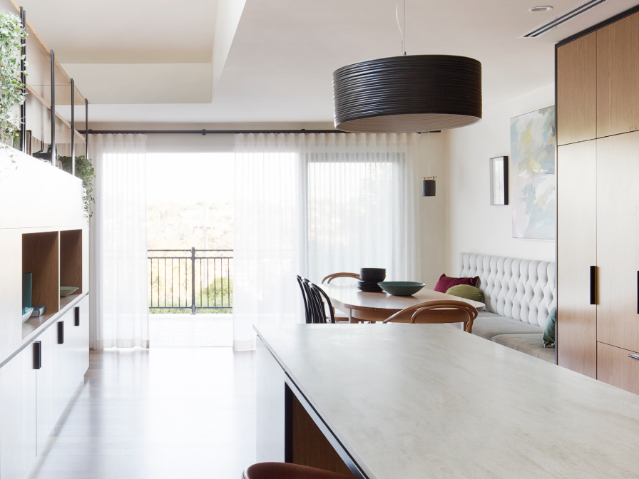 White s-fold sheer curtains on a ceiling track in a modern kitchen-dining area.