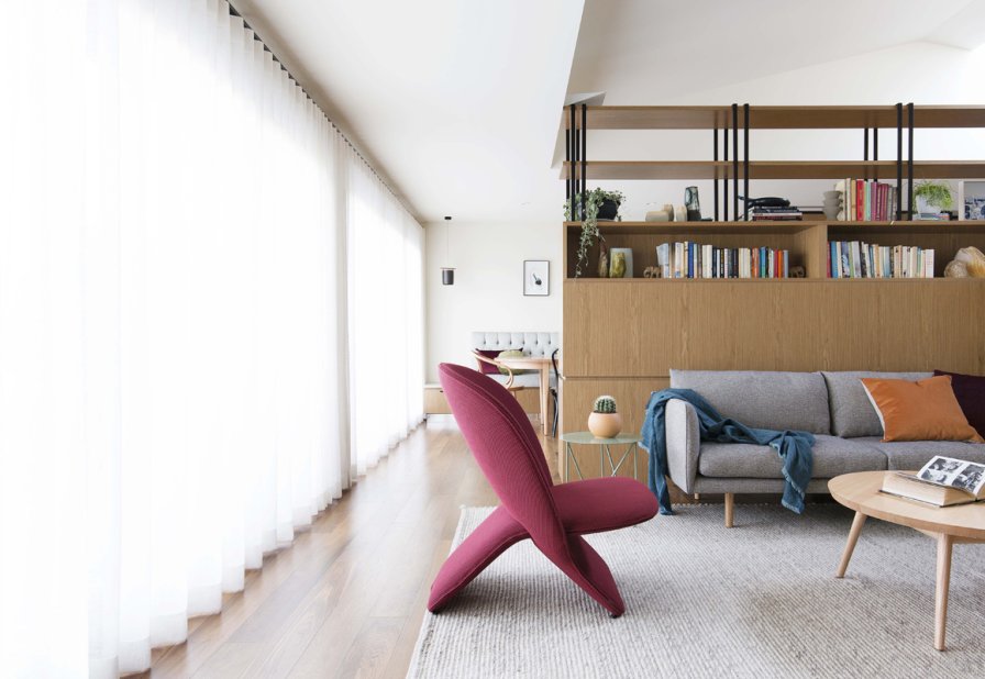 Pearl-white draped curtains beside a sofa with cream and burgundy cushions.