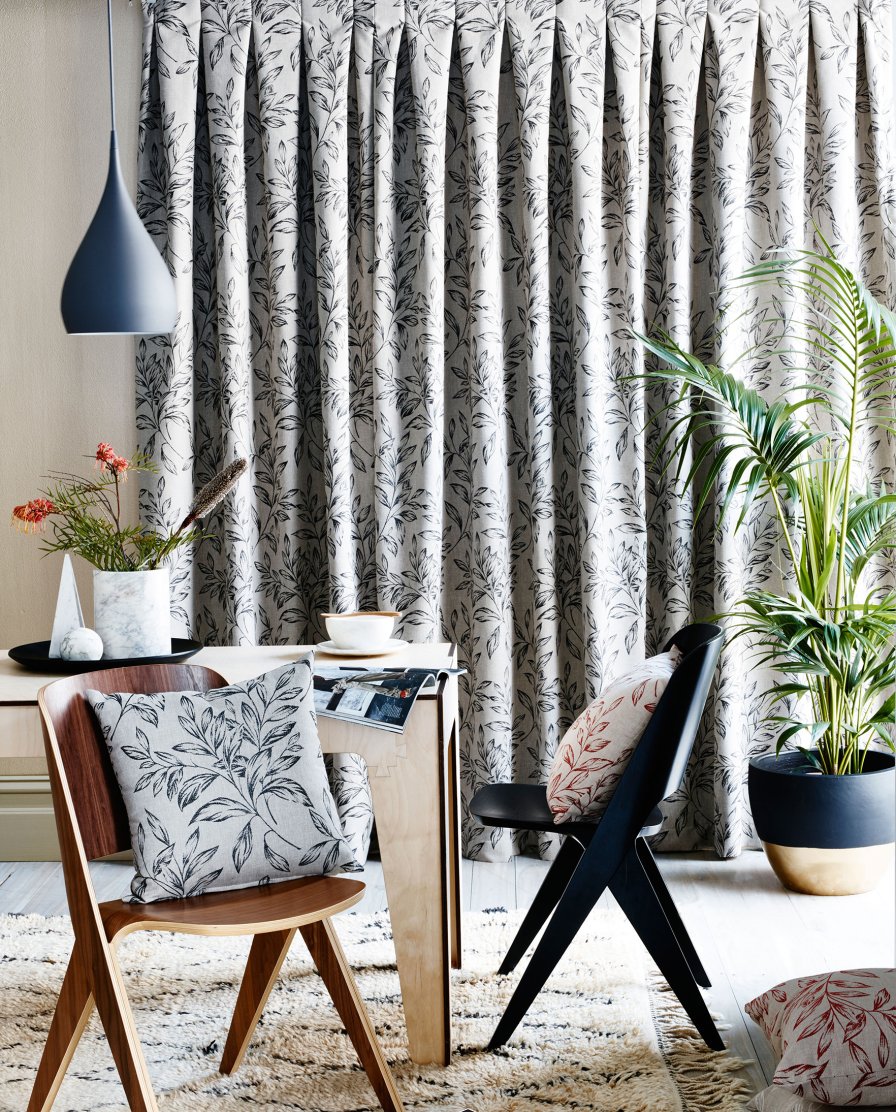 Close-up of black and white kingfisher-patterned curtains with a pinch pleat heading.