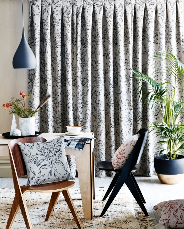 Close-up of black and white kingfisher-patterned curtains with a pinch pleat heading.