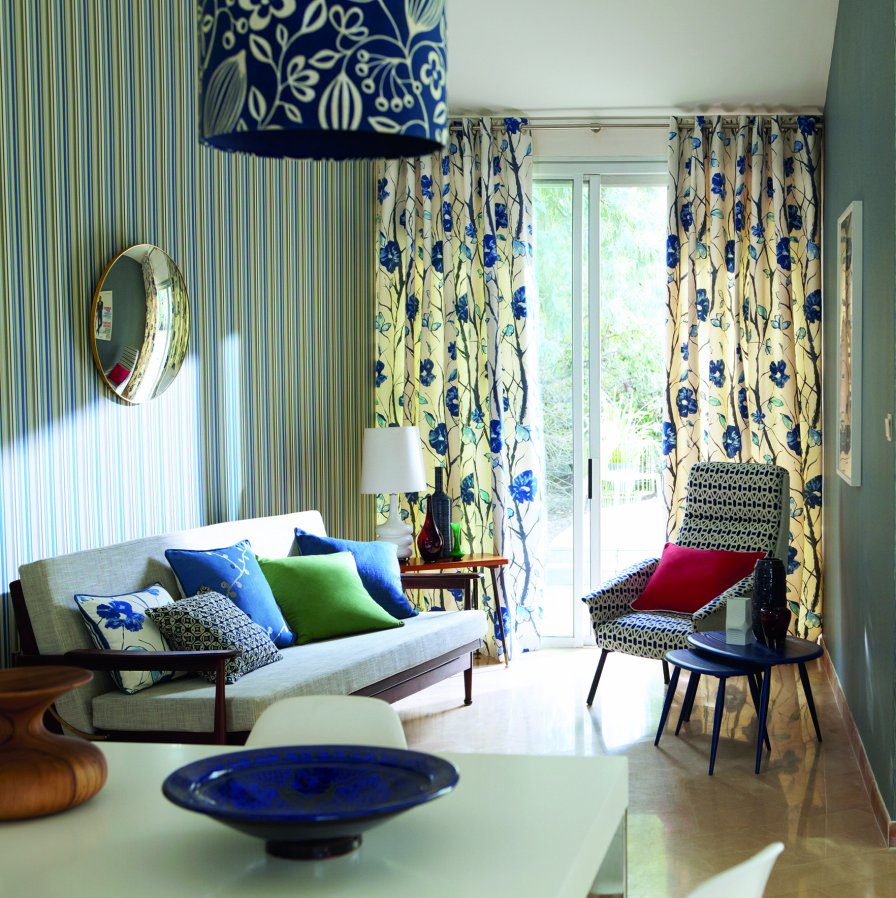 Living room with chalk, indigo and denim patterned curtains and a blue accent chair.