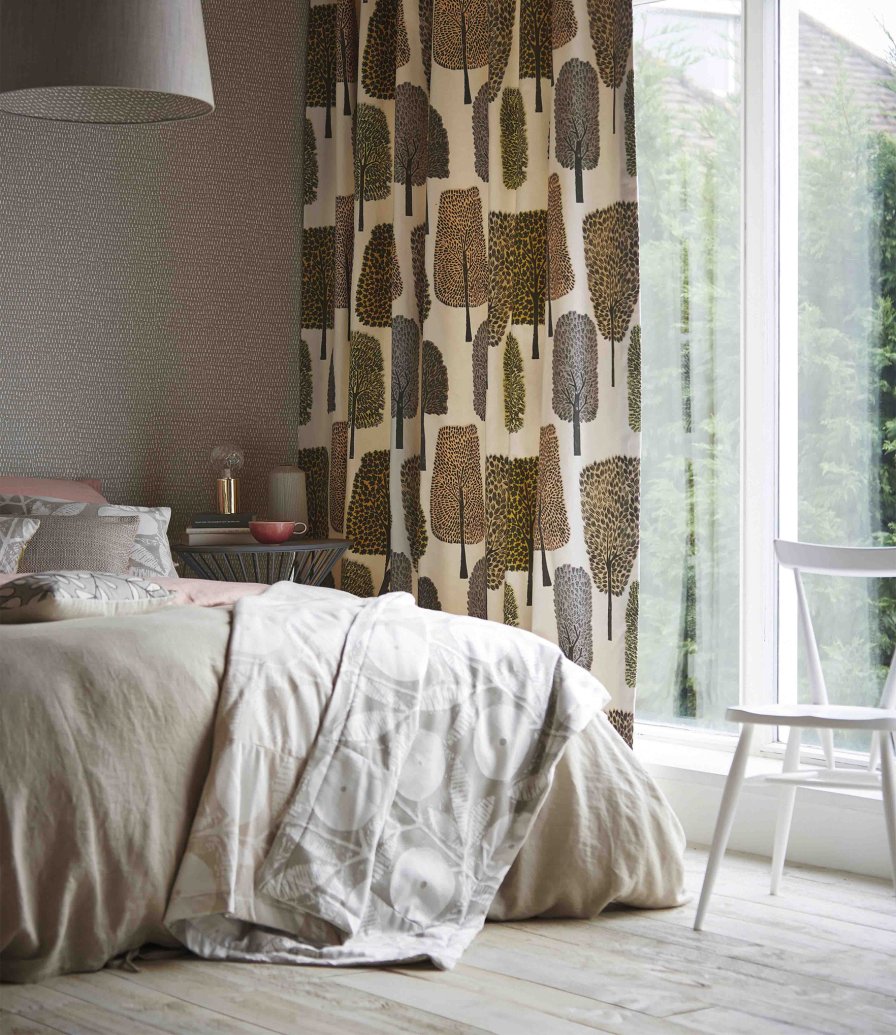 Bedroom with muted blush, toffee and taupe tree-patterned curtains on a cream ground.