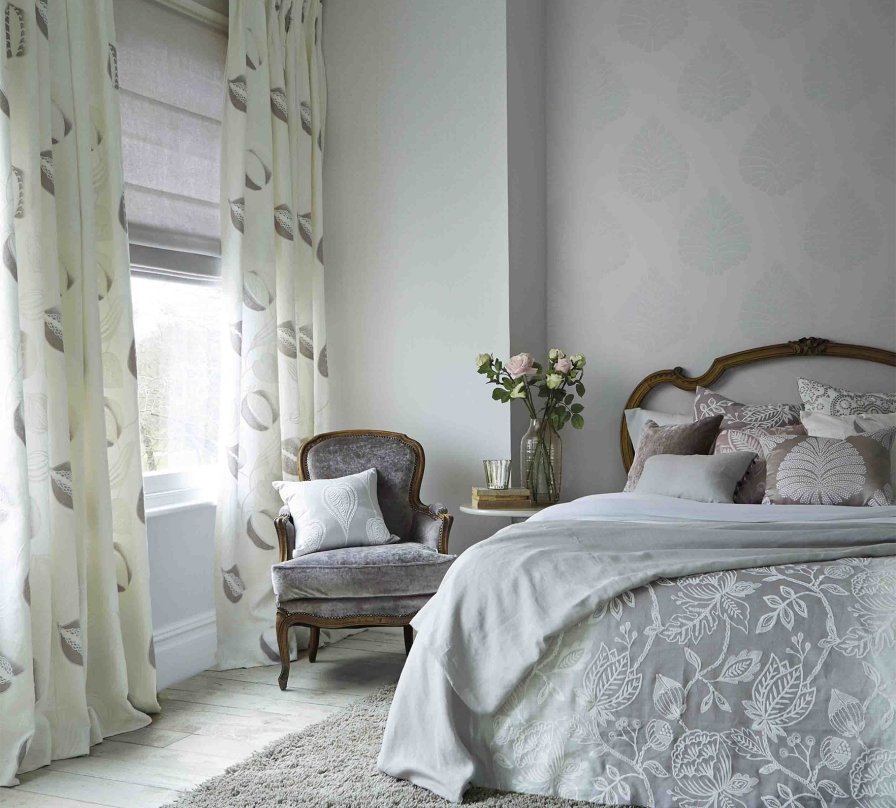 A welcoming guest bedroom with soft grey curtains