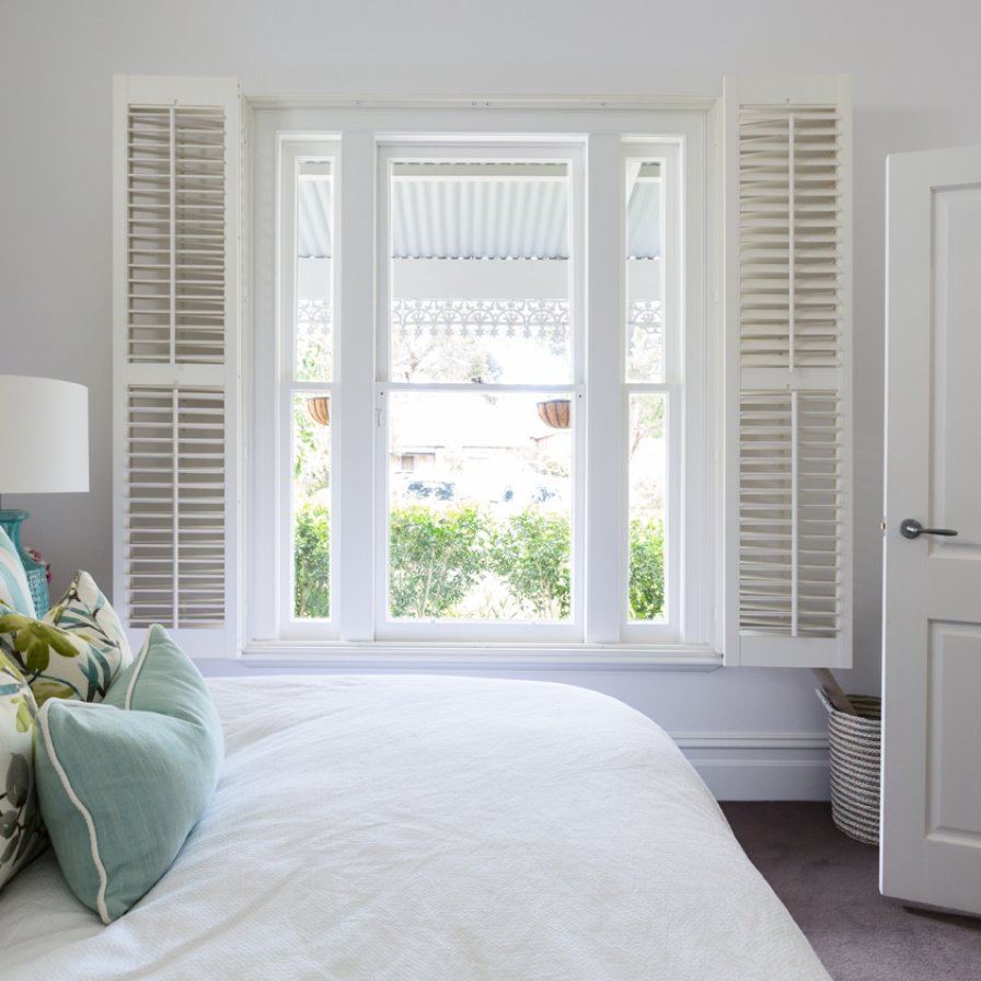 Plantation shutters styled in a bed room with natural decor