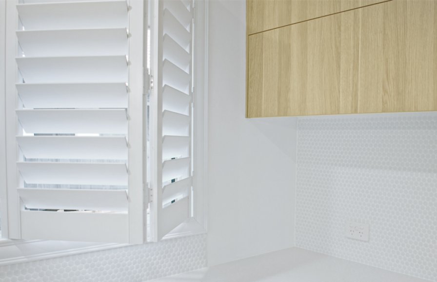 White shutters accentuated with greenery in a styled room