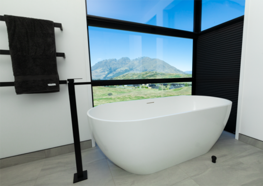 Black roller blind partly lowered in a bathroom with a white bathtub and mountain views.