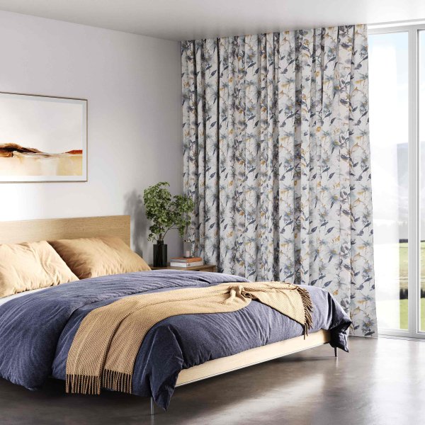 Bedroom with grey and blue patterned curtains and matching blue bedding.