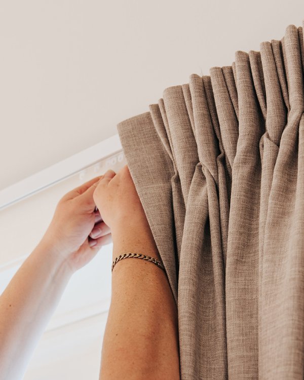 A Russells installer fitting window coverings during a professional home installation.
