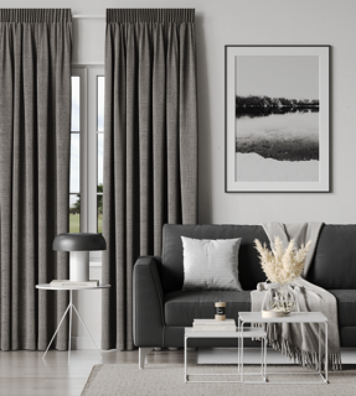 Long dark grey floor-to-ceiling curtains in a modern living room with artwork.