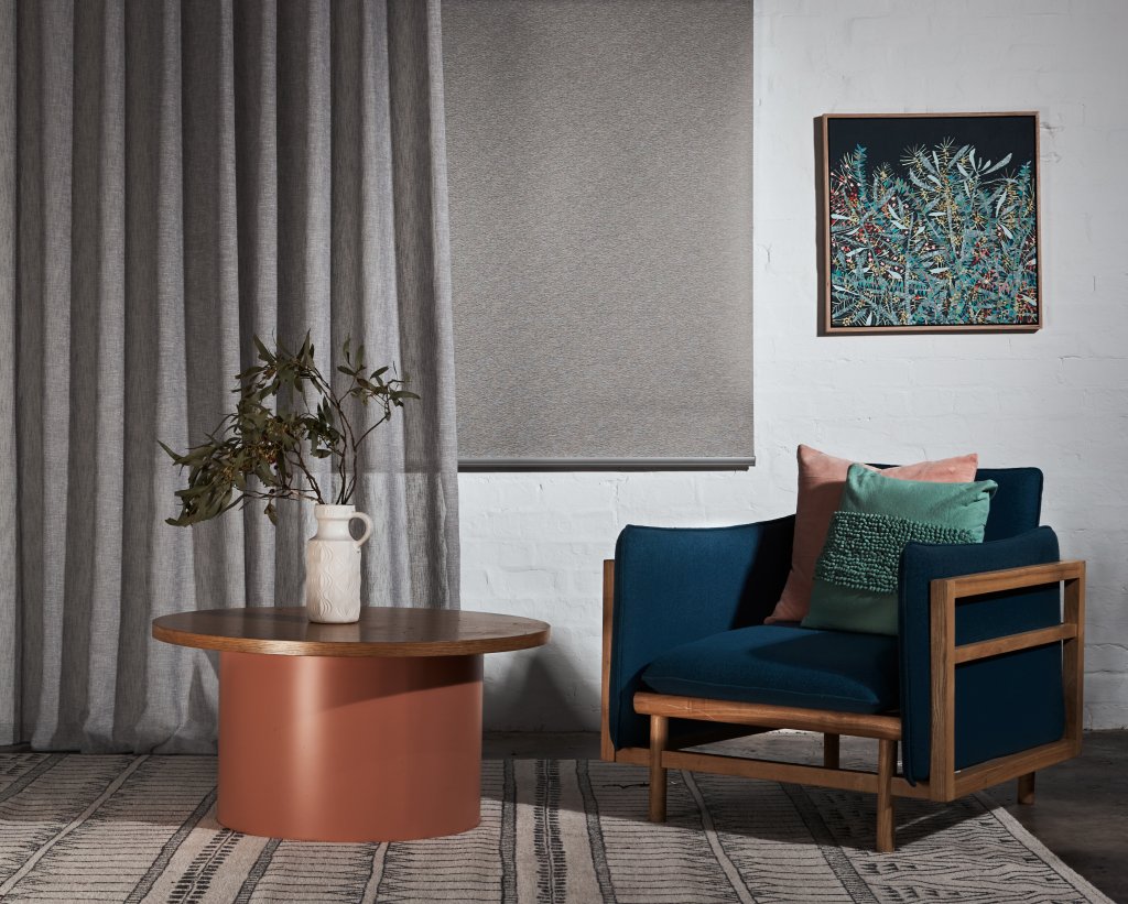 Grey roller and sunscreen blinds in a modern open-plan living space.
