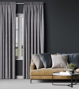 Soft grey pencil pleat curtains drawn across a living-room window beside a mustard-yellow sofa.