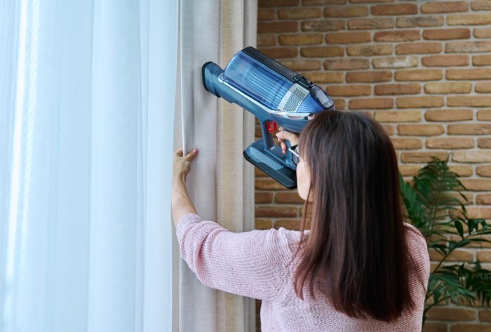 Vacuuming sheer curtains to clean them