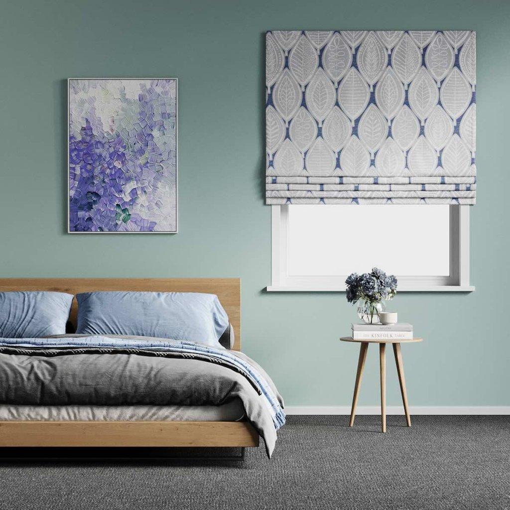 Grey and navy leaf-patterned roman blind over a window in a sage-green bedroom.