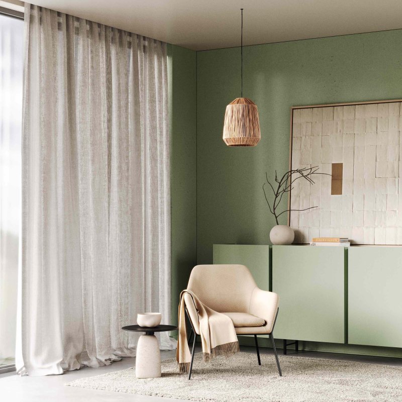 Taupe striped curtains in a living room with a pale green wall and cream armchair.