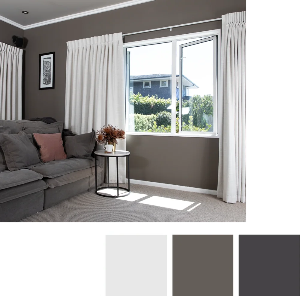Sheer white curtains filtering sunlight in a modern living room with a grey sofa.