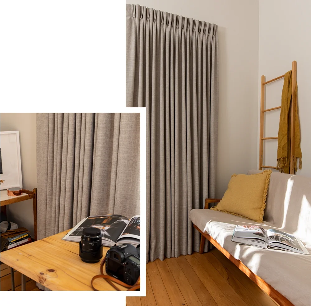 Grey patterned curtains in a bedroom with a wooden desk and gold accessories.