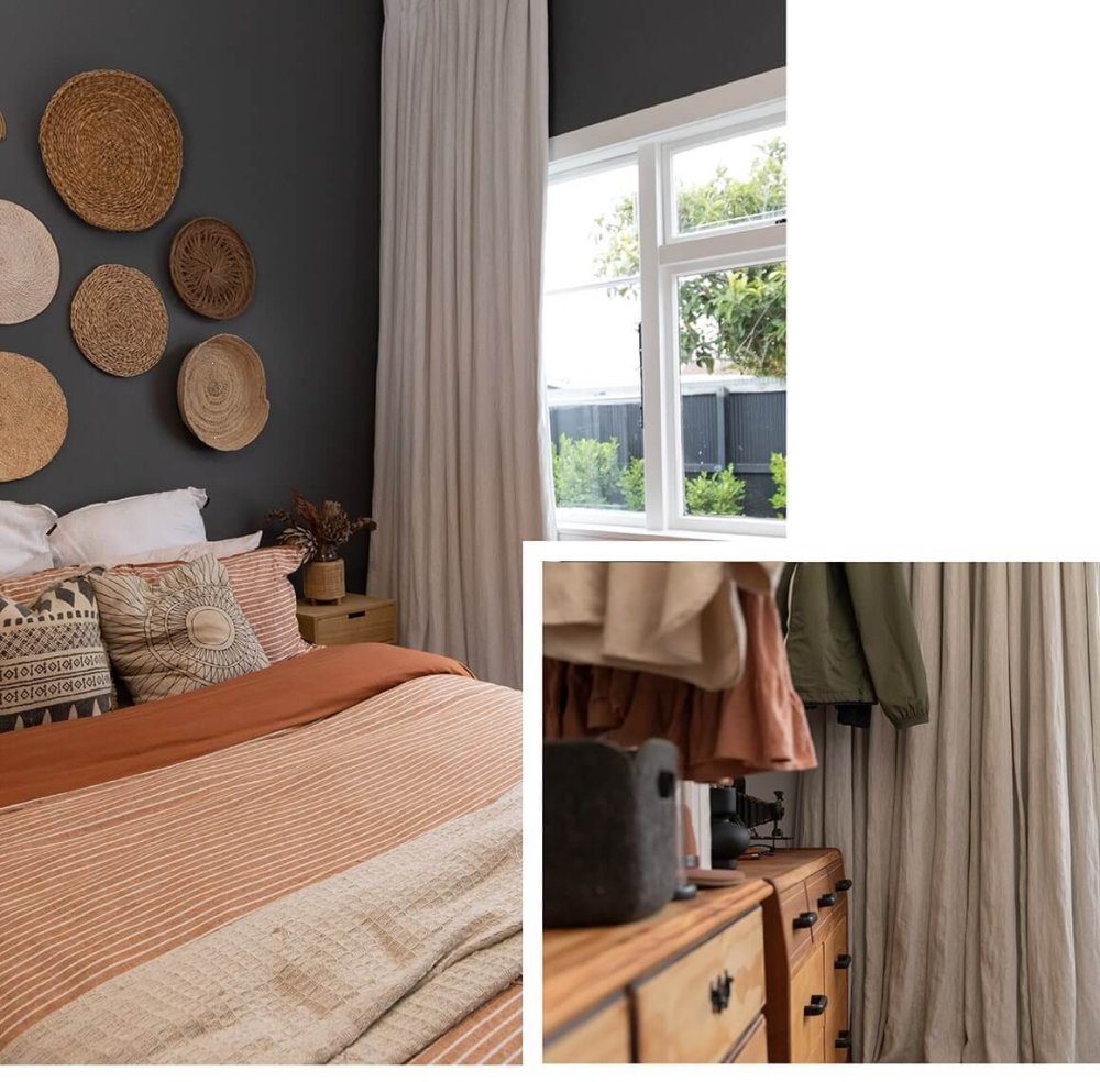Bedroom with charcoal walls, pale grey curtains, woven wall baskets and terracotta bedding.