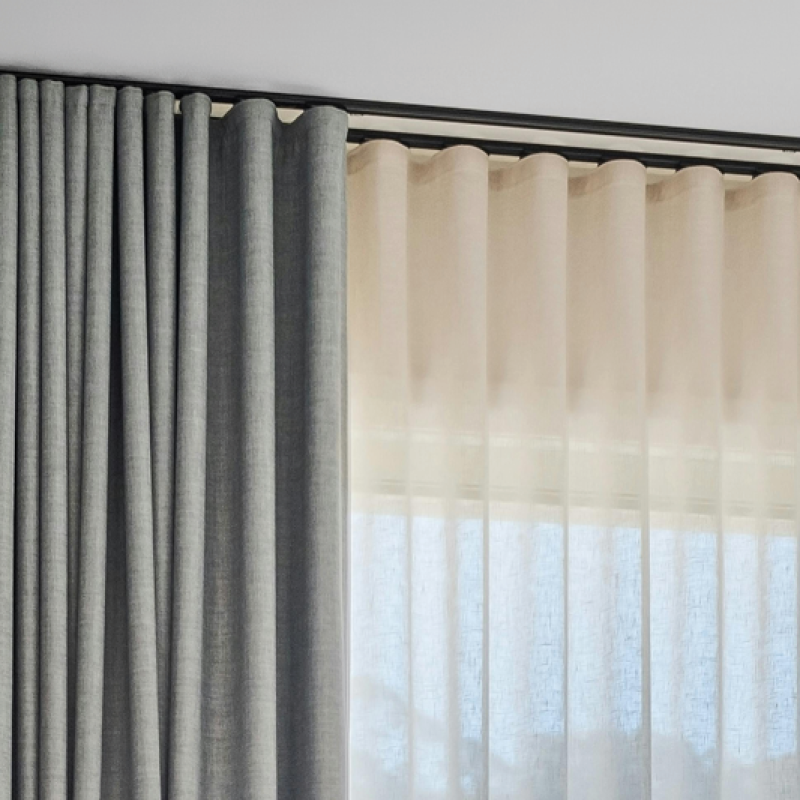 Grey curtains showing the smooth, even waves of an s-fold heading style.