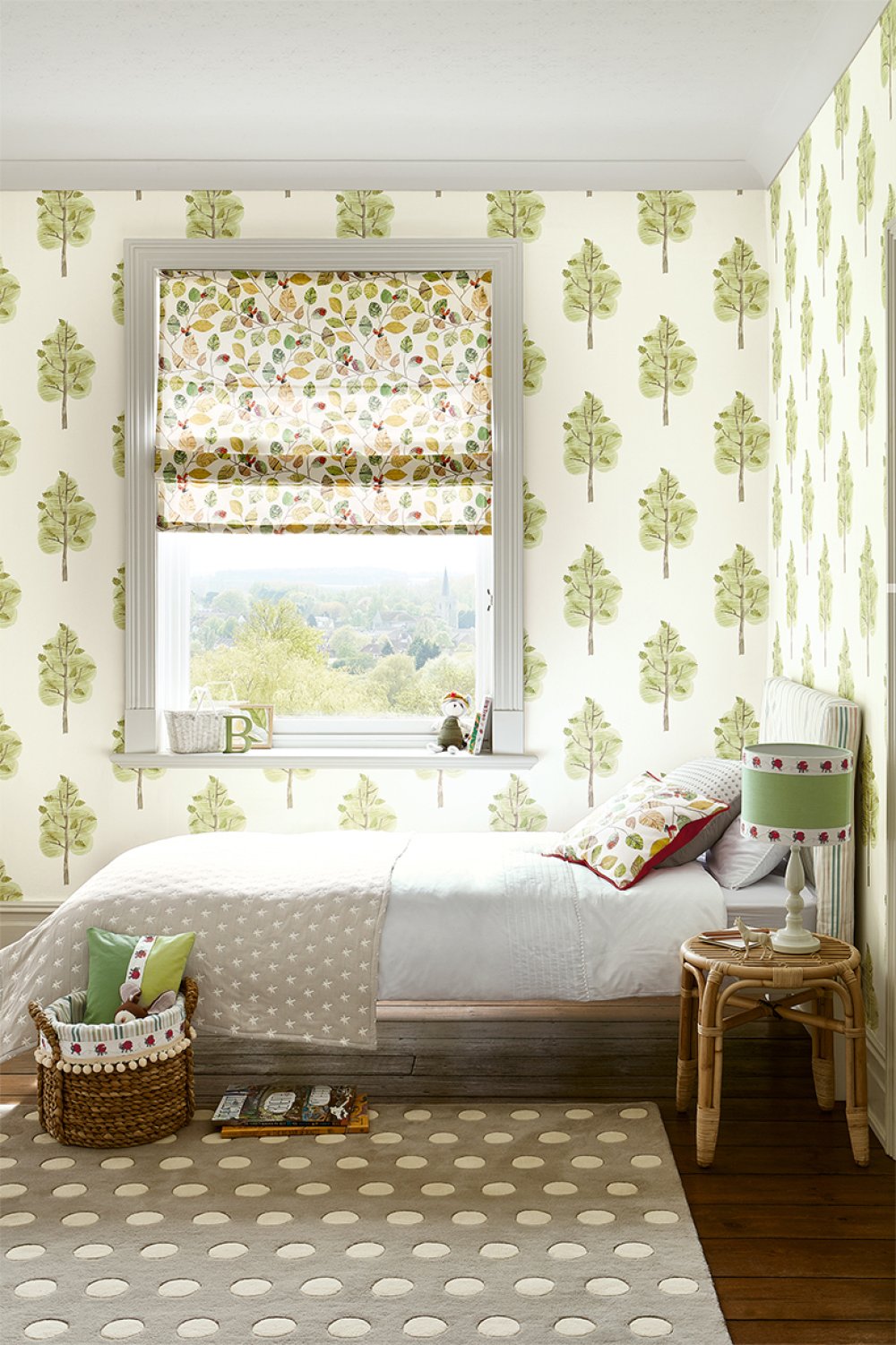 Cream and green woodland-creature print roman blind above a child's bed.